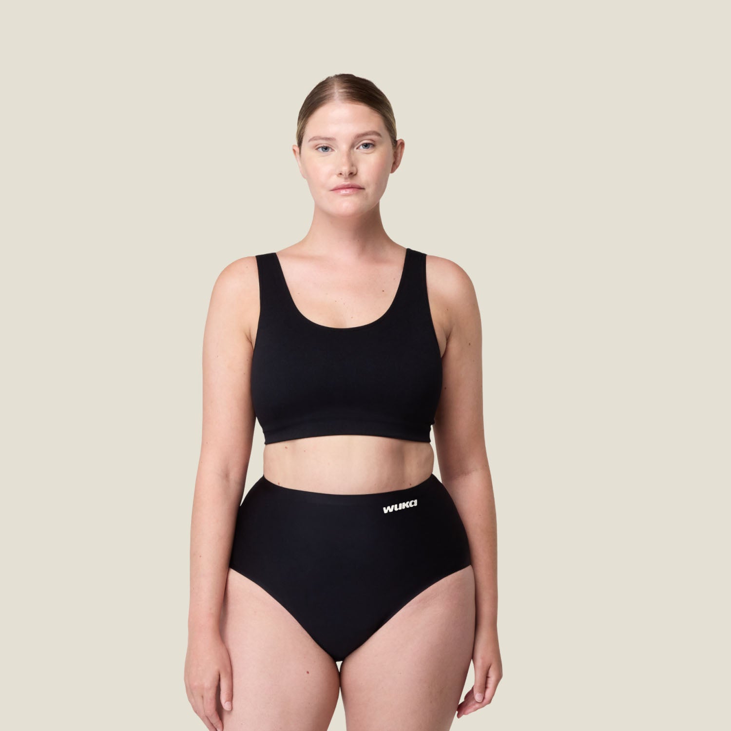 Woman wearing WUKA Stretch™ High Waist Period Pants in black for super heavy flow, offering full coverage and maximum comfort during periods.