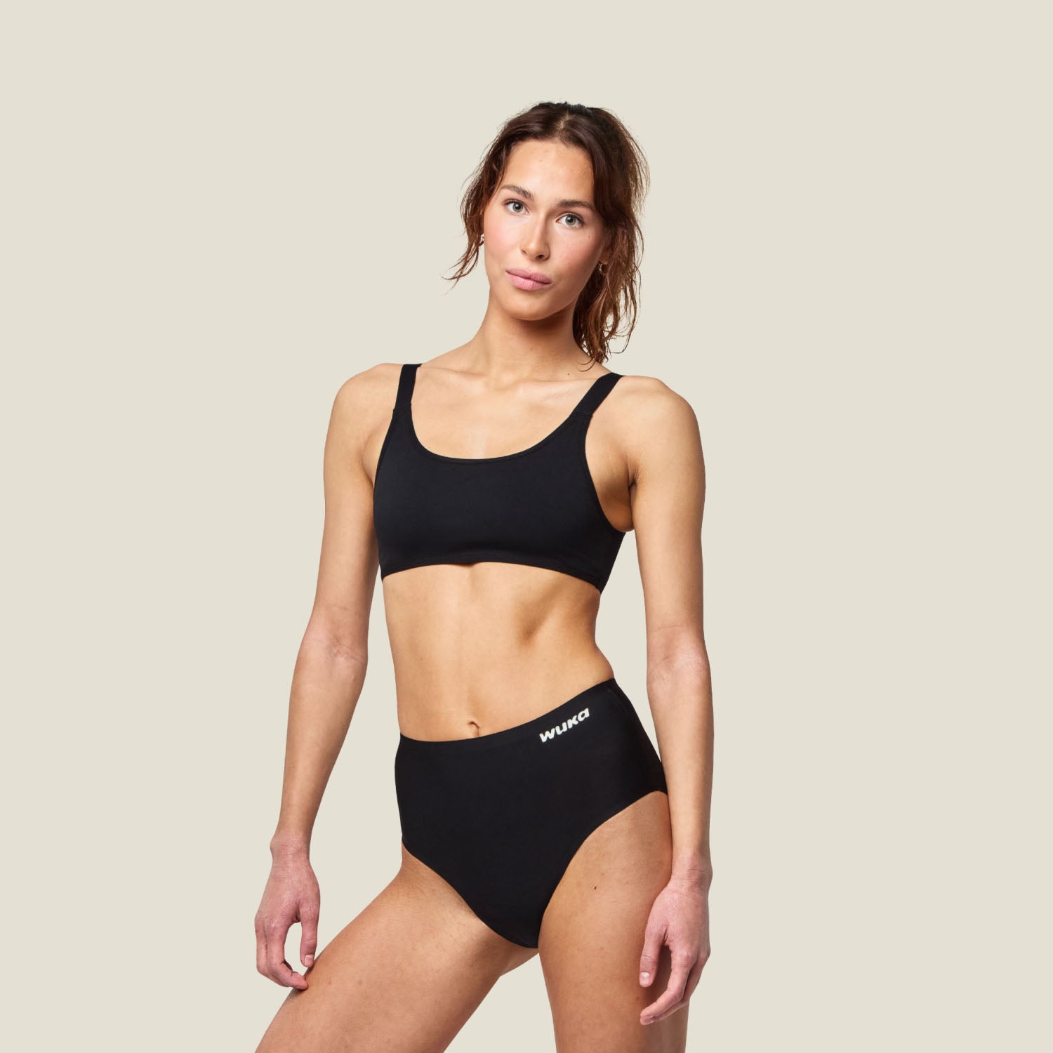Female model wearing WUKA Stretch™ Super Heavy Period Brief in black, showcasing a mid-waisted fit and seamless comfort.