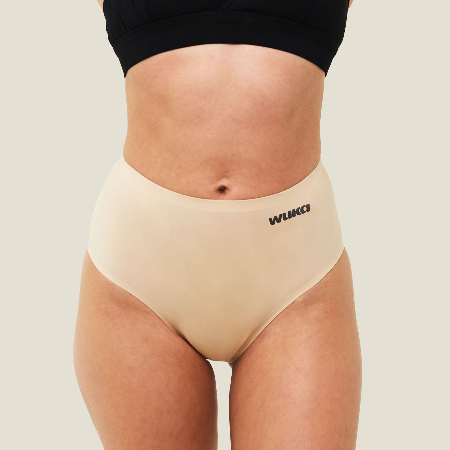 Teen model wearing WUKA Teen Stretch Seamless Midi Brief in Light Nude for heavy flow, showcasing front view and comfortable fit.