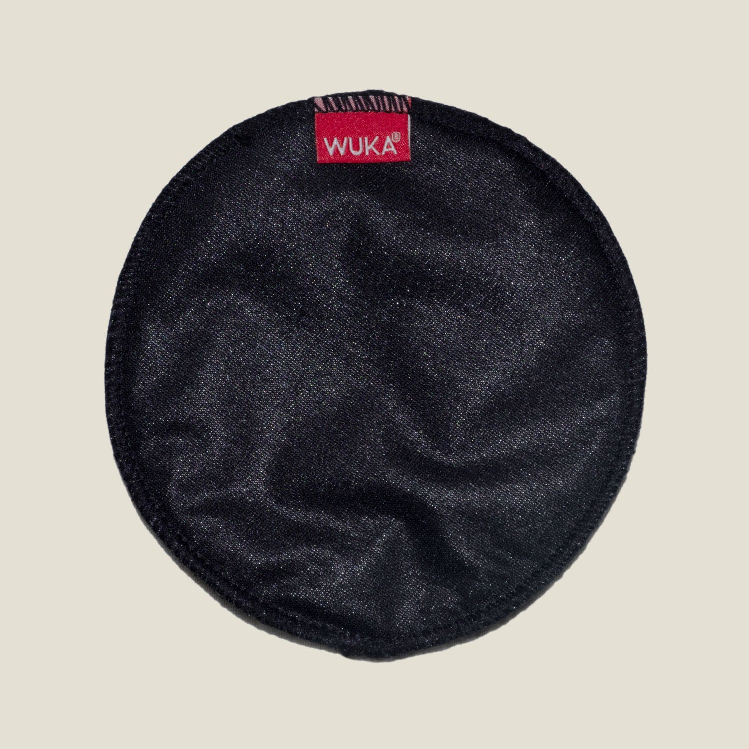 Close-up of WUKA Maternity Nursing Pad showing the soft, black outer layer with signature red WUKA logo tag.