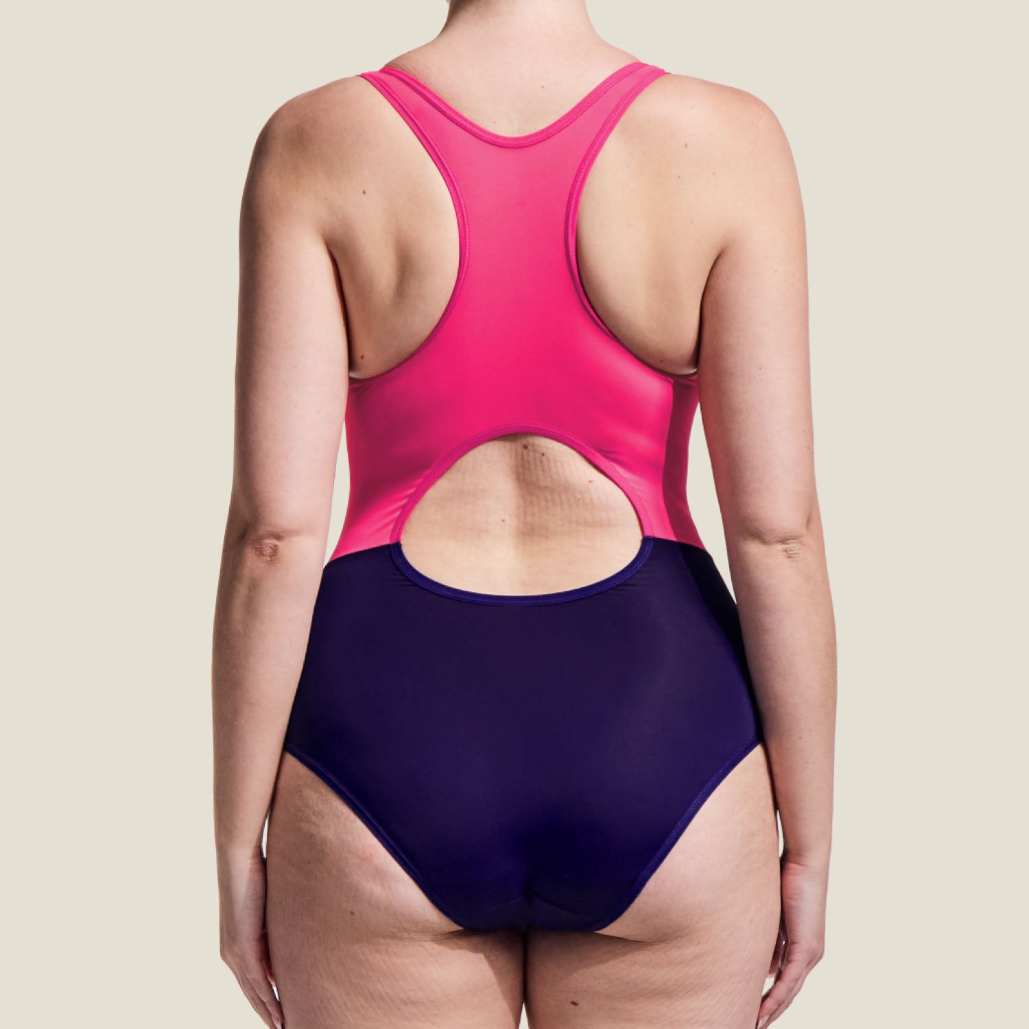 Rear view of the WUKA Racerback Period Swimsuit in pink and purple, featuring a keyhole cutout and supportive racerback design.