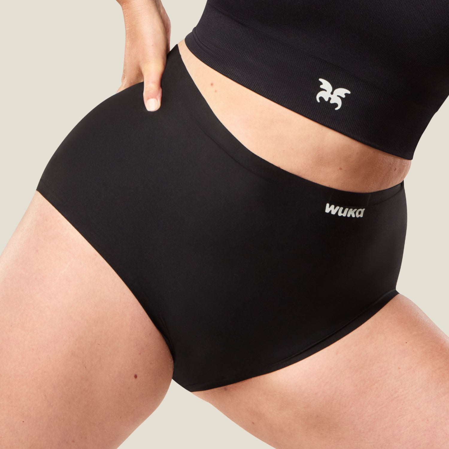 Zoomed-in shot of waistband and logo on WUKA Stretch™ High Waist Period Pants in black, engineered for super heavy flow and superior absorption.