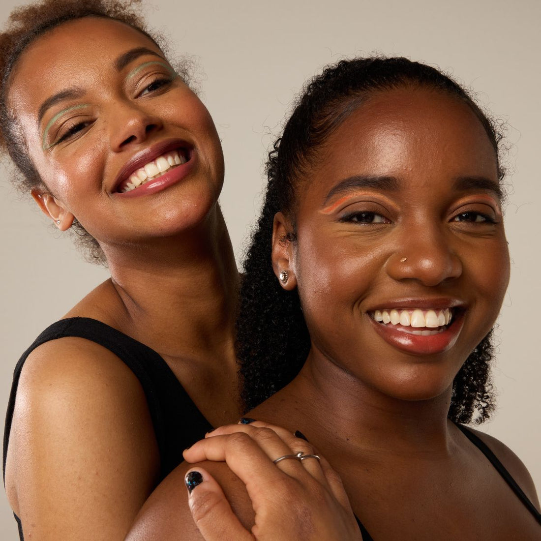 two girls standing close together and smiling 