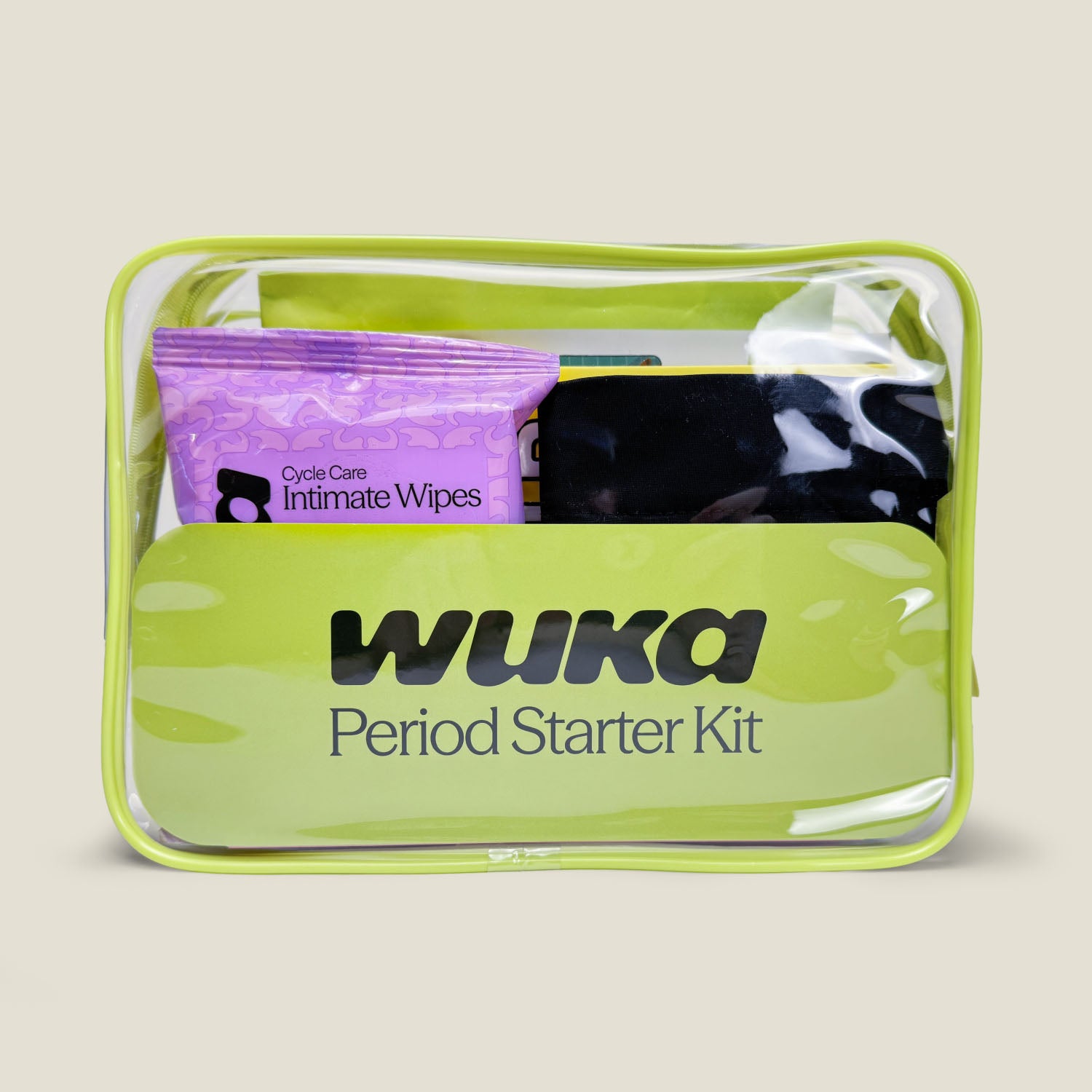 Front view of WUKA Period Starter Kit in a clear green zip pouch, showing included Cycle Care Intimate Wipes, black Stretch™ period pants, and other essentials for first periods.