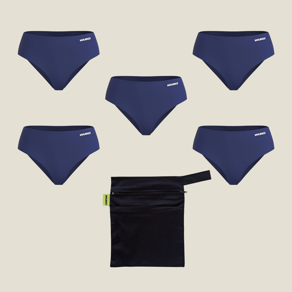 Flat lay image of WUKA Teen Stretch™ Period Pants 5-pack in navy blue, ideal for school weeks with a mix of flow levels, shown alongside a dark teal waterproof wet bag.